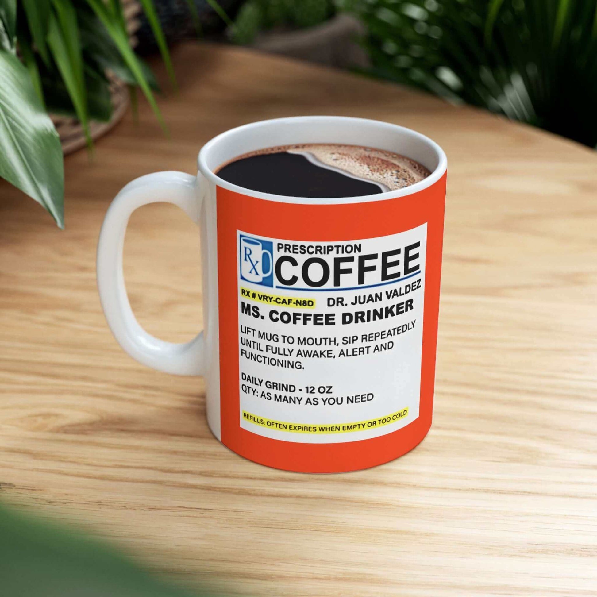 Prescription Coffee Mug - For Her (11oz, 15oz) on a wooden table with greenery in the background