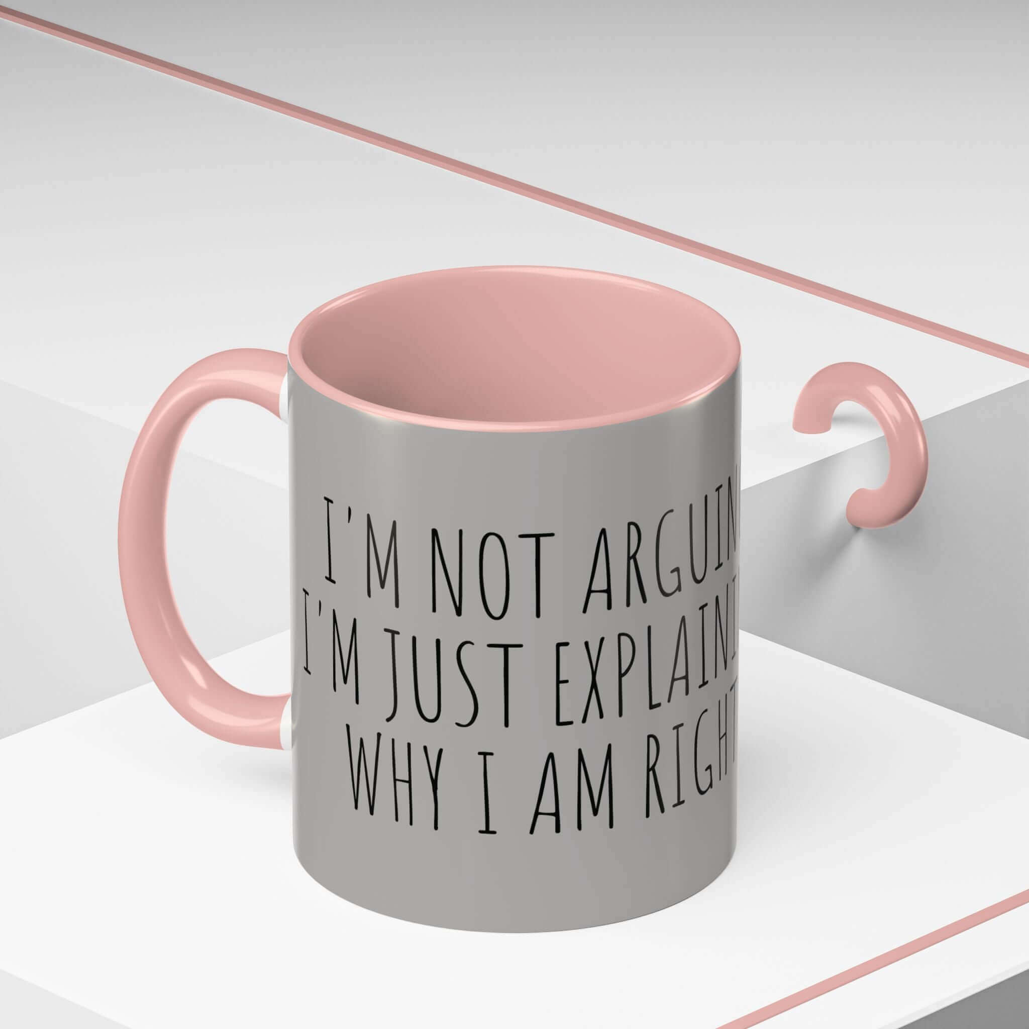 Grey ceramic mug with pink interior and handle, featuring the text 