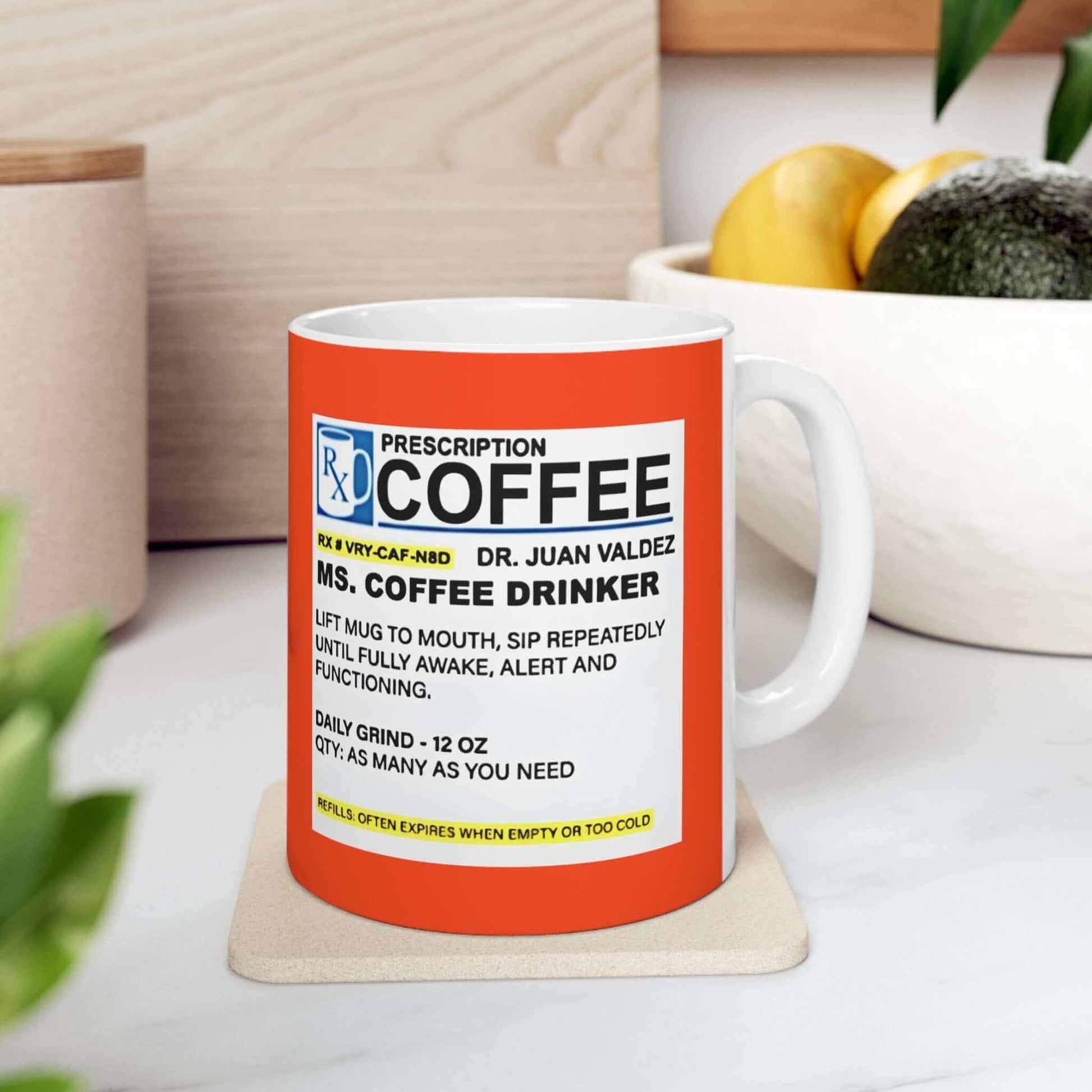 Prescription Coffee Mug - For Her (11oz, 15oz) on a white table with fruit in the background. Durable ceramic, BPA and Lead-free, microwave & dishwasher-safe.