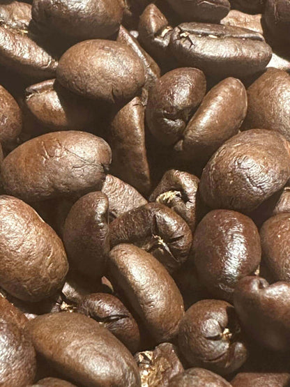 Close-up of roasted coffee beans showcasing the rich texture and color of House Blend, highlighting nutty sweetness and chocolate notes.