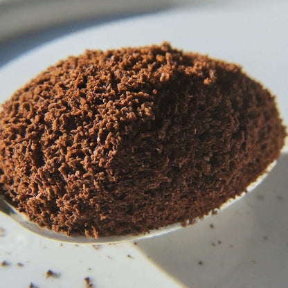 Close-up of ground Naturally Flavored Almond Coffee, highlighting rich texture and premium Arabica quality.