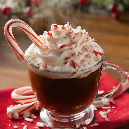 Delicious Candy Cane flavored coffee topped with whipped cream and candy pieces in a clear mug.