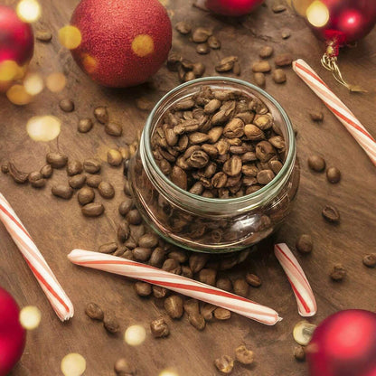 Candy Cane flavored coffee beans with festive decorations and candy canes on a wooden surface.